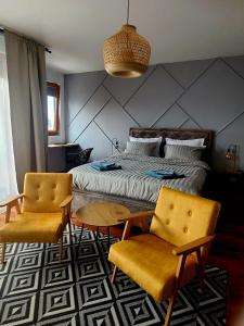 een slaapkamer met een bed en 2 stoelen en een tafel bij Stan na dan Krsmanovic in Čačak