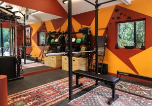 einen Fitnessraum mit orangefarbenen Wänden und einer Bank in einem Zimmer in der Unterkunft The Iflissen Pavilion - Luxury Villa in Lamorlaye