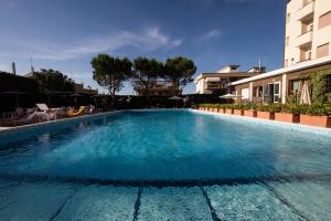 a large blue swimming pool next to a building at Hotel Touring in Falconara Marittima