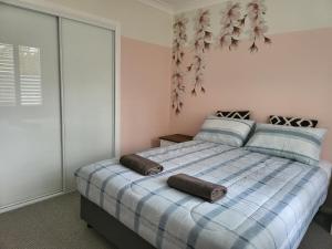 um quarto com uma cama com um edredão azul e branco em Jervis Bay Waters Edge Retreat - Access to Deep Water - Free late check out 2pm on Sundays, low season em Woollamia