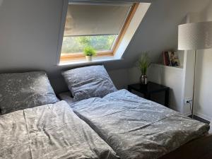 ein Bett in einem Schlafzimmer mit einem Fenster und einer Tagesdecke in der Unterkunft Ferienwohnung Lopperland in Hinte in Hinte