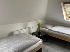 ein Schlafzimmer mit 2 Betten und einer Vase aus Blumen auf dem Tisch in der Unterkunft Ferienwohnung Lopperland in Hinte in Hinte