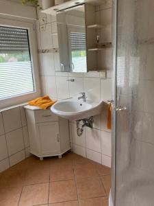 ein Bad mit einem Waschbecken und einem Spiegel in der Unterkunft Ferienwohnung Lopperland in Hinte in Hinte