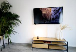 a living room with a table and a painting on the wall at MILPAU Gladbeck 1 - Modernes und zentrales Premium-Apartment mit Privatparkplatz, Queensize-Bett, Netflix, Nespresso und Smart-TV in Gladbeck