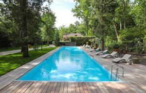 a swimming pool with lounge chairs next to a wooden deck at The Iflissen Pavilion - Luxury Villa in Lamorlaye