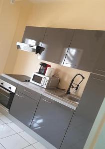 uma cozinha com um lavatório e um micro-ondas em The FFG House - Appartements meublés Douala Cite des palmiers, Bonamoussadi em Douala