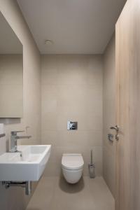 La salle de bains est pourvue de toilettes blanches et d'un lavabo. dans l'établissement Byt s výhľadom na hrad, à Bratislava