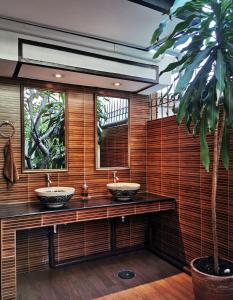 a bathroom with two sinks and a palm tree at TAVEE Guesthouse in Bangkok