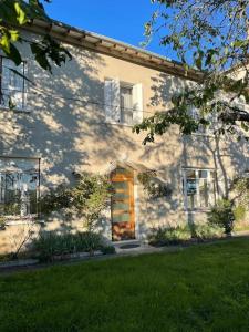 una casa blanca con una puerta y un patio de césped en Location maison à Chadron : Haute Loire 