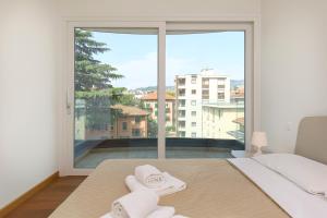 una camera da letto con una grande finestra con asciugamani su un letto di Roggia 16 by Quokka 360 - central flat with balcony a Viganello