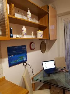 una mesa de cristal con un ordenador portátil en la habitación en Appartamento bello a Milano, en Milán