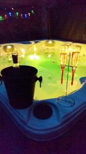 two wine glasses in front of a tub of water at Maison de 2 chambres avec piscine privee jacuzzi et jardin clos a Wangen in Wangen