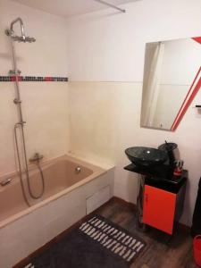 La salle de bains est pourvue d'une baignoire et d'un lavabo. dans l'établissement Maison de 2 chambres avec piscine privee jacuzzi et jardin clos a Wangen, à Wangen