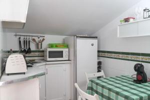 uma cozinha com um frigorífico branco e uma mesa em Casa Rural Las Cuevas de Setenil em Setenil