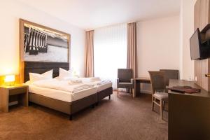 une chambre d'hôtel avec un lit, une table et des chaises dans l'établissement Villa Auszeit Hotel Garni, à Bansin