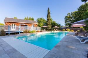 una piscina en un patio con una casa en Hôtel Miléade Le Domaine de la Blairie - Saumur, en Saint-Martin-de-la-Place