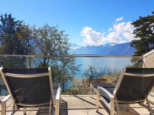 twee stoelen op een balkon met uitzicht op het water bij Montreux Lake View Apartments and Spa - Swiss Hotel Apartments in Montreux