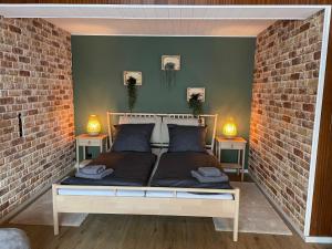 a bedroom with a bed in a brick wall at Westerwälder Hof Windhagen in Windhagen