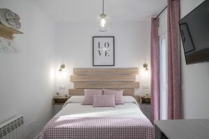セテニル・デ・ラス・ボデガスにあるCasa Rural Las Cuevas de Setenilのベッドルーム1室(ピンクと白の毛布付きのベッド1台付)