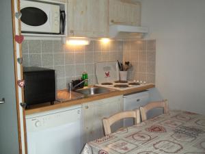 una piccola cucina con lavandino e forno a microonde di STUDIO AVEC BALCON a Luz-Saint-Sauveur