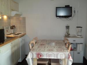 una cucina con tavolo e TV a parete di STUDIO AVEC BALCON a Luz-Saint-Sauveur