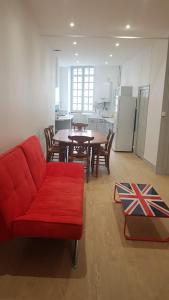a living room with a red couch and a table at Hyper centre - 3 chambres - Gare - wifi - cosy in Bourg-en-Bresse
