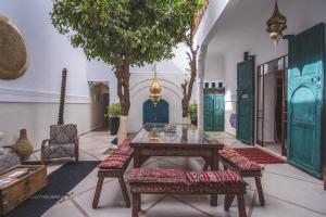 um quarto com uma mesa, cadeiras e árvores em Riad Villa Berna under Swiss Management em Marraquexe