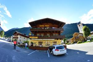 大格洛克纳山道旁富施珀斯特法什酒店的停在建筑物前停车场的汽车