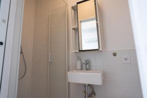 La salle de bains est pourvue d'un lavabo et d'une douche avec un miroir. dans l'établissement Sundeck botel - party boat, à Bratislava