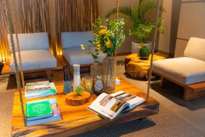 Glamday Style Okinawa Yomitan Hotel & Resort في يوميتان: غرفة معيشة مع طاولة مع كتب وكراسي