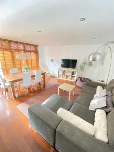 Una sala de estar con un sofá y un comedor. en Alojamientos Rías Baixas- Casa Castillejos- Carril, en Vilagarcía de Arousa