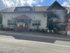 a white brick house on the side of a street at Rooms Balkovec in Dragatuš