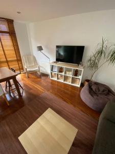 a living room with a flat screen tv and a table at Alojamientos Rías Baixas- Casa Castillejos- Carril in Vilagarcia de Arousa