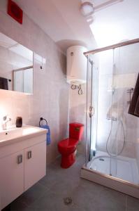 bagno con servizi igienici rossi e doccia di Gudauri Smart Apartment a Gudauri