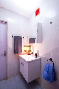 a white bathroom with a sink and a shower at Gudauri Smart Apartment in Gudauri