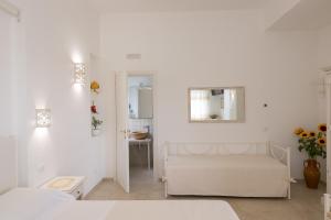 チステルニーノにあるDimora San Quirico - rooms & foodの白い部屋(ベッド1台、鏡付)