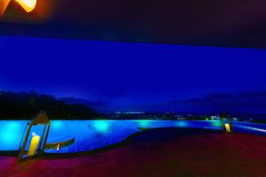 uma vista para uma piscina à noite em Glamday Style Okinawa Yomitan Hotel & Resort em Yomitan