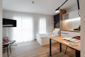 The Place Herzogenaurach - Serviced Apartments في هيرتسوجيناوراخ: غرفة معيشة مع أريكة وطاولة