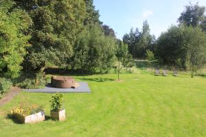 un jardin avec deux plantes en pot dans un champ dans l'établissement Riverbank Cottage, à Lancaster