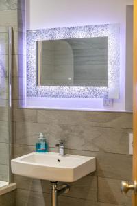 a bathroom with a sink and a mirror at Riverbank Cottage in Lancaster