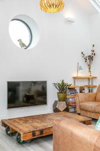 ein Wohnzimmer mit einem Couchtisch und einem Flachbild-TV in der Unterkunft Riverbank Cottage in Lancaster