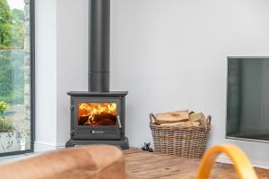 ein Kamin in einem Wohnzimmer mit Fernseher in der Unterkunft Riverbank Cottage in Lancaster + 14 Fotos