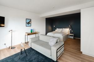 um quarto de hotel com uma cama e um sofá em The Place Herzogenaurach - Serviced Apartments em Herzogenaurach