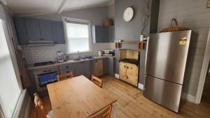 eine Küche mit einem Kühlschrank aus Edelstahl und einem Holztisch in der Unterkunft 'Pickett's Cottage' - Circa 1868 - Oldest in Knox! in Boronia + 9 Fotos
