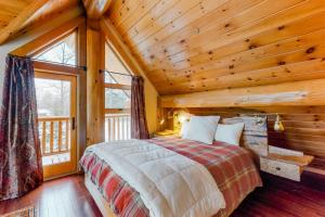 um quarto com uma cama num chalé de madeira em Snow Lion em Carrabassett