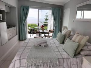 sypialnia z dużym łóżkiem i widokiem na ocean w obiekcie De La Hilcremat w mieście Simonstad