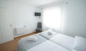 Un dormitorio blanco con una cama con dos toallas encima. en Villa de Gredos, en Navarredonda de Gredos 95 fotos más