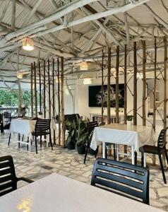 The Three P Beach Resort & Dive Center في Romblon: غرفة طعام مع طاولات وكراسي في مبنى