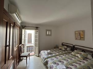 エステポナにあるVillacana 2626のベッドルーム1室(ベッド1台、椅子、窓付)