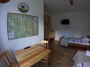 Liszna的住宿－Kyczyrka，一间设有桌子、床和时钟的房间